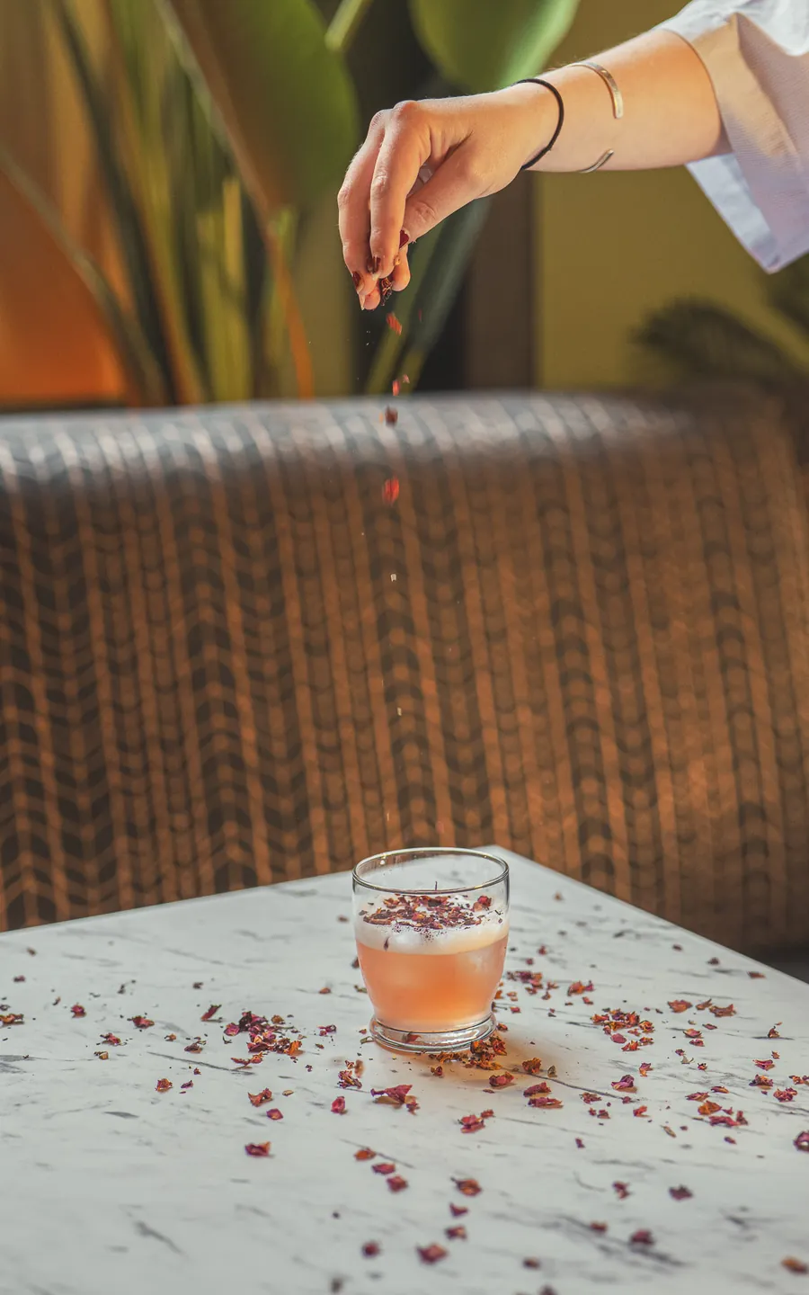 Dried petals sprinkled over a pink cocktail
