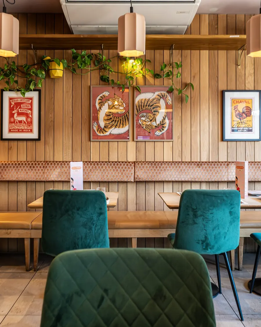 Kal Dosa's wood-panelled dining room with green velvet chairs