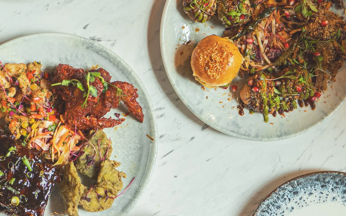 Small plates and pink cocktails on a marble table, seen from above